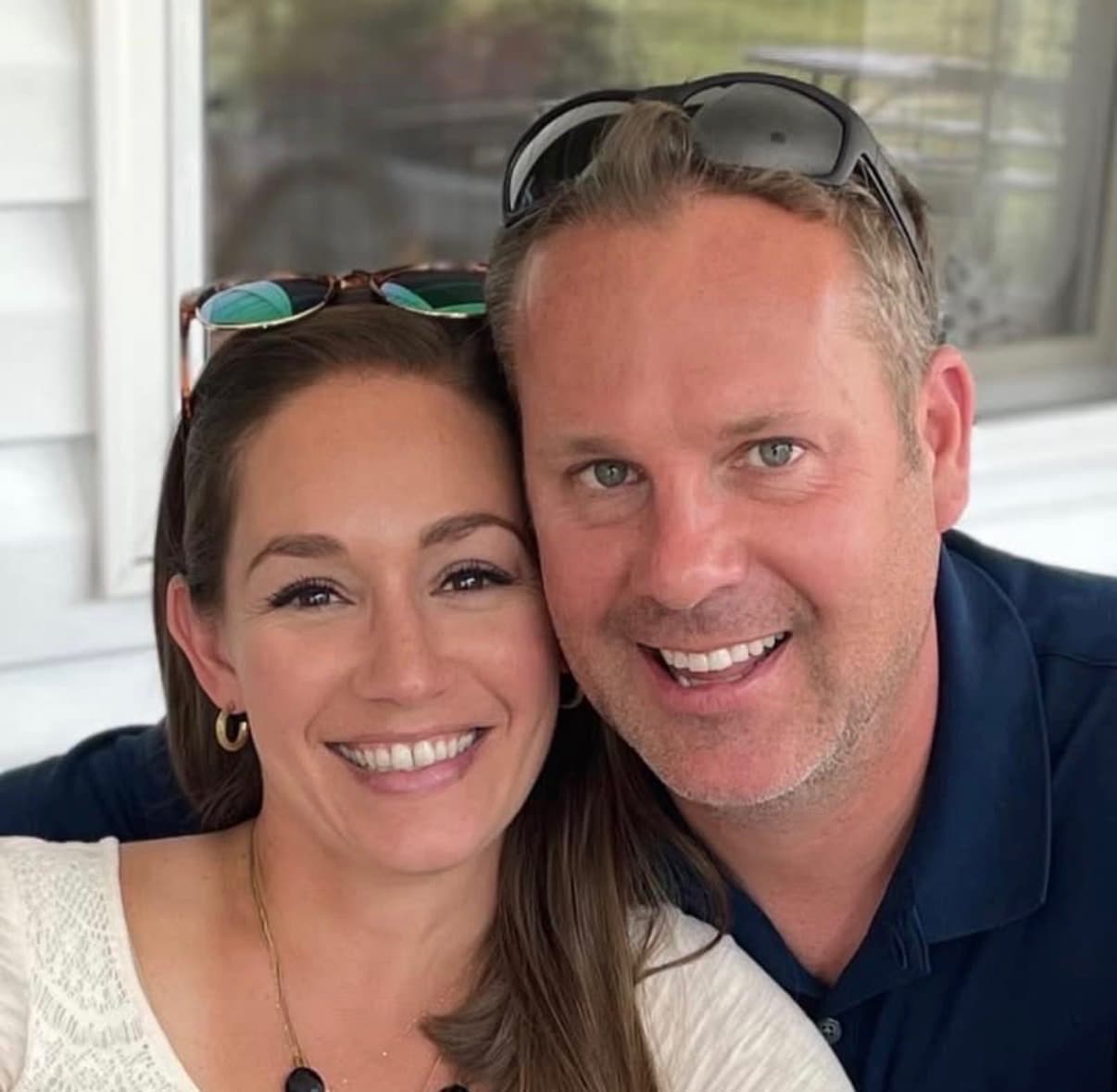 Chip and Autumn Bolton, owners of Hearth & Patio, smiling together on a porch